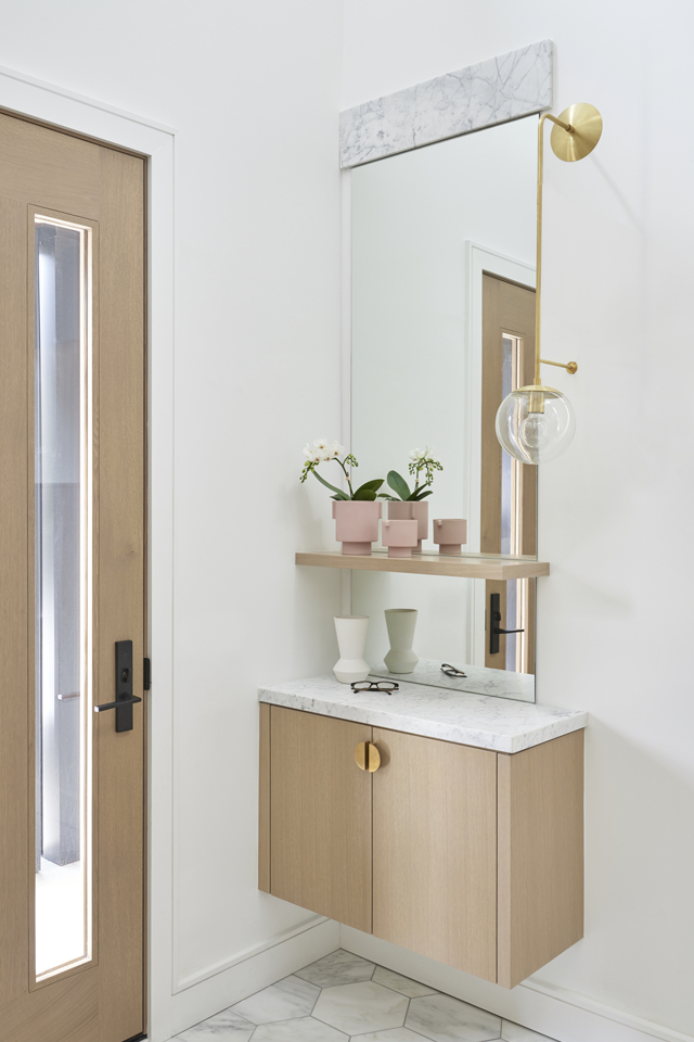 Bright entryway with cabinet storage and large rectangular mirror 